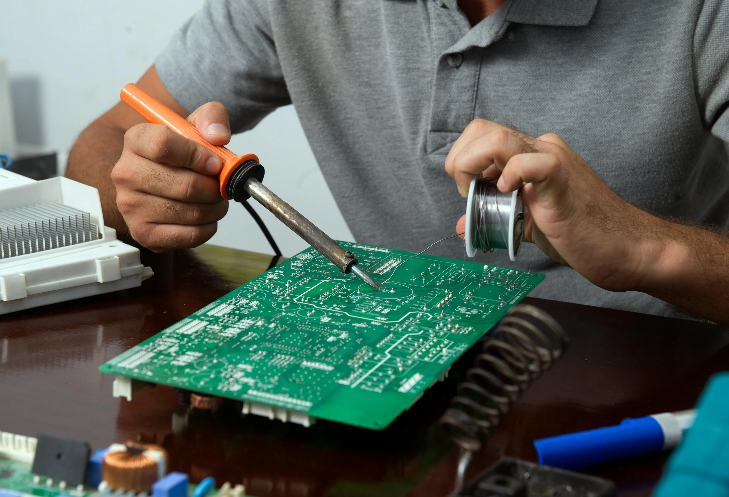 A technician soldering components on a circuit board